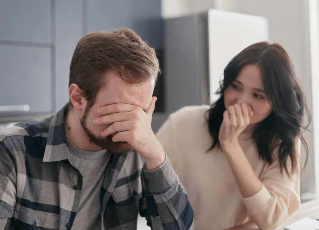 Homem com a mão no rosto expressando frustração ao lado de uma mulher, ilustrando o desânimo de conviver com cheiro forte que parece impossível de tirar.
